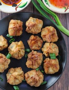 some food is on a black plate with green onions