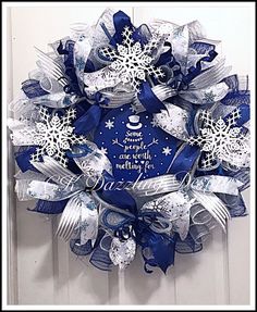 a blue and white christmas wreath with snowflakes on the front door for someone's special holiday