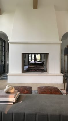 a living room filled with furniture and a fire place in the middle of an open floor plan