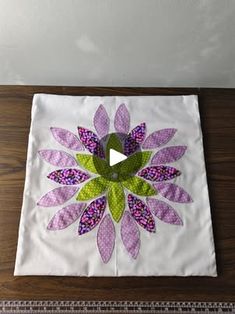 a piece of cloth with a flower on it sitting on top of a wooden table