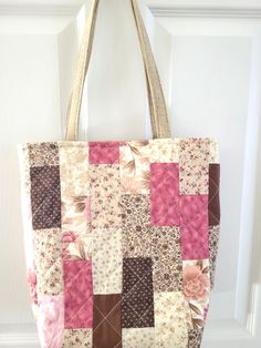 a pink and brown patchwork bag hanging on a door