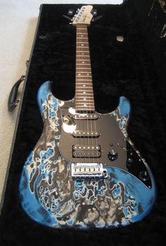 a blue and black guitar sitting on top of a case