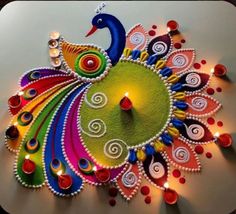 a colorful peacock made out of paper with candles on it's face and eyes