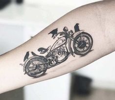 a person with a tattoo on their arm has a motorcycle tattooed on it's arm