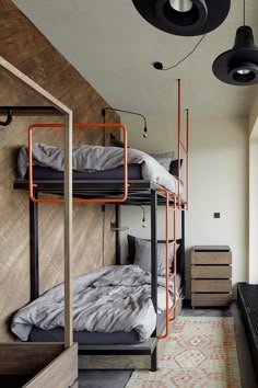 bunk beds are lined up in a room with wooden walls and carpeted flooring