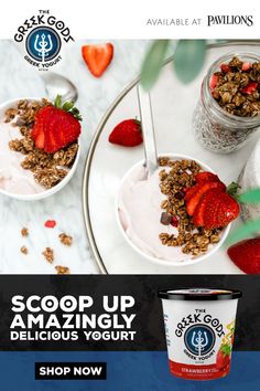 two cups of yogurt with strawberries and granola in them on a table