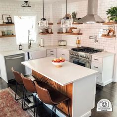 a kitchen with an island and chairs in it