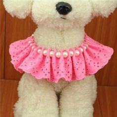 a teddy bear wearing a pink dress with pearls on it's chest and collar