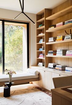 a living room with bookshelves and a couch in front of a large window