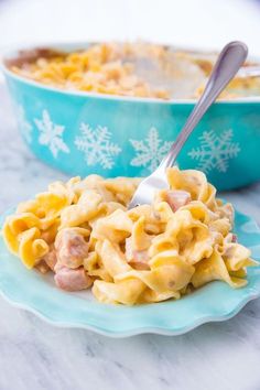 a bowl of macaroni and cheese on a plate with a spoon in it