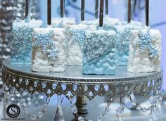 there are four cakes on the table with frosting and snowflakes around them