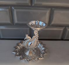 a silver candle holder sitting on top of a table