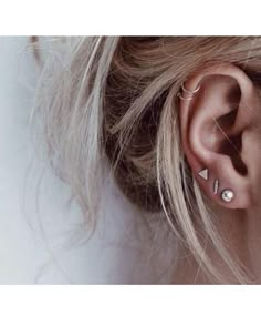 a woman's ear with two piercings on it