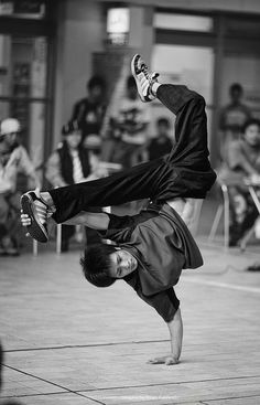 a man doing a handstand in front of a crowd