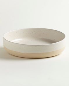 a white and beige bowl sitting on top of a table