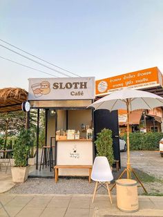 a small stand with an umbrella on the side of it that says sloth cafe