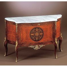 an ornately decorated wooden cabinet with marble top