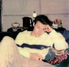 an old photo of a man sitting on a couch with his head in his hands