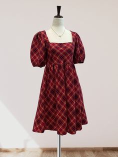 Featuring a checkered plaid print on woven fabric, this mini dress is perfect for the fall and winter months. The square neckline and short puff sleeves add a touch of femininity, while the babydoll waistline and smocking detail on the back provide a comfortable and flattering fit. Complete with a back tie detail and convenient side pockets, this dress is the perfect choice for the holiday season. Casual Plaid Dress With Square Neck For Fall, Casual Square Neck Plaid Dress For Fall, Plaid Puff Sleeve Dress For Picnics, Fitted Plaid Dress With Puff Sleeves For Casual Wear, Casual Fitted Plaid Dress With Puff Sleeves, Fitted Casual Plaid Dress With Puff Sleeves, Fall Plaid Dress With Square Neck, Plaid Puff Sleeve Dress For Picnic, Square Neck Plaid Dress For Picnic