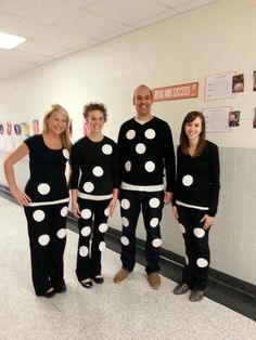 four people dressed up in black and white polka dot pajamas, standing next to each other