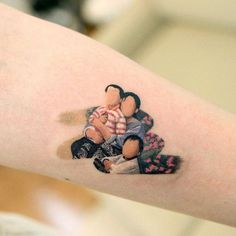 a woman with a tattoo on her arm holding a baby