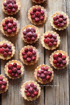 raspberry tarts with powdered sugar on wooden table top view from above