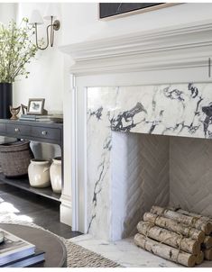 a living room with a fireplace and white marble mantel in the middle of it