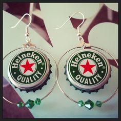 a pair of beer bottle caps are hanging from hoop earrings