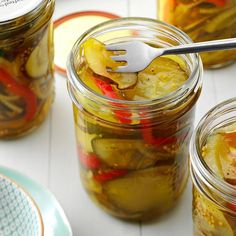 pickled vegetables in jars with a fork