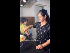 a woman standing in front of a counter preparing food