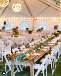 an outdoor tent with tables and chairs set up for a wedding reception in the grass