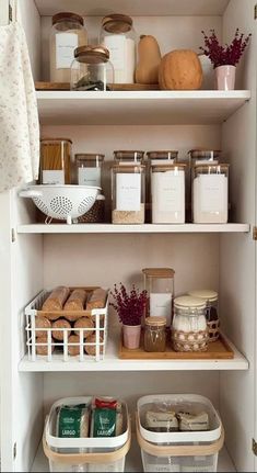 an organized pantry with white shelves filled with food and storage containers on top of them