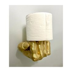 a toilet paper holder made out of gold foil with a roll of toilet paper on top