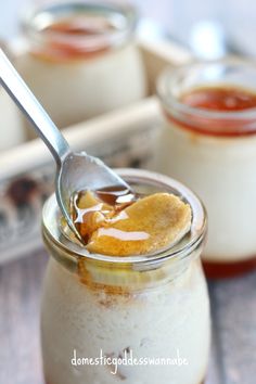 a spoon with some food in it on a table next to another jar filled with liquid