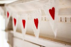 red and white hearts are hanging on the window sill with burlaps