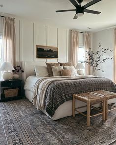 a bedroom with a bed, rug and ceiling fan