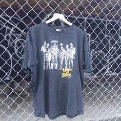 a t - shirt hanging on a chain link fence with the words west side story printed on it