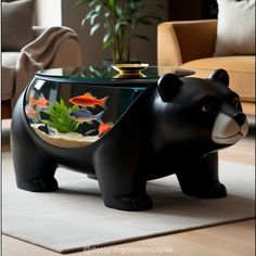 a black bear shaped coffee table with fish in it's bowl on the floor