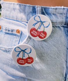 two cherries are on the back of a pair of jean shorts with blue bows