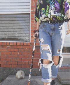 a man in ripped jeans holding a baseball bat