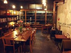 an empty restaurant with tables and chairs in front of a book shelf filled with books