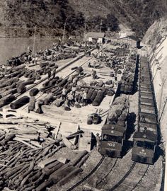 an old black and white photo of train tracks with logs on the ground next to it