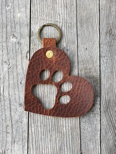 a heart shaped keychain with a paw print on it