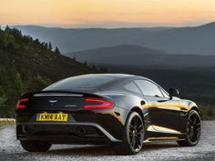 a black sports car parked on top of a gravel road