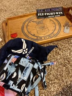 an assortment of items on the floor in front of a wooden tray that says u s air force fly - tight - twin