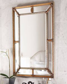 a bathroom mirror sitting on top of a white counter next to a black and white sink