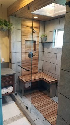 a walk in shower sitting next to a wooden bench