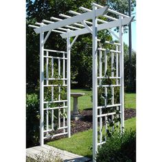 an outdoor garden with a white trellis