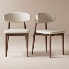 two white chairs sitting next to each other on top of a beige floored surface