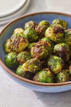 a blue bowl filled with brussel sprouts on top of a table